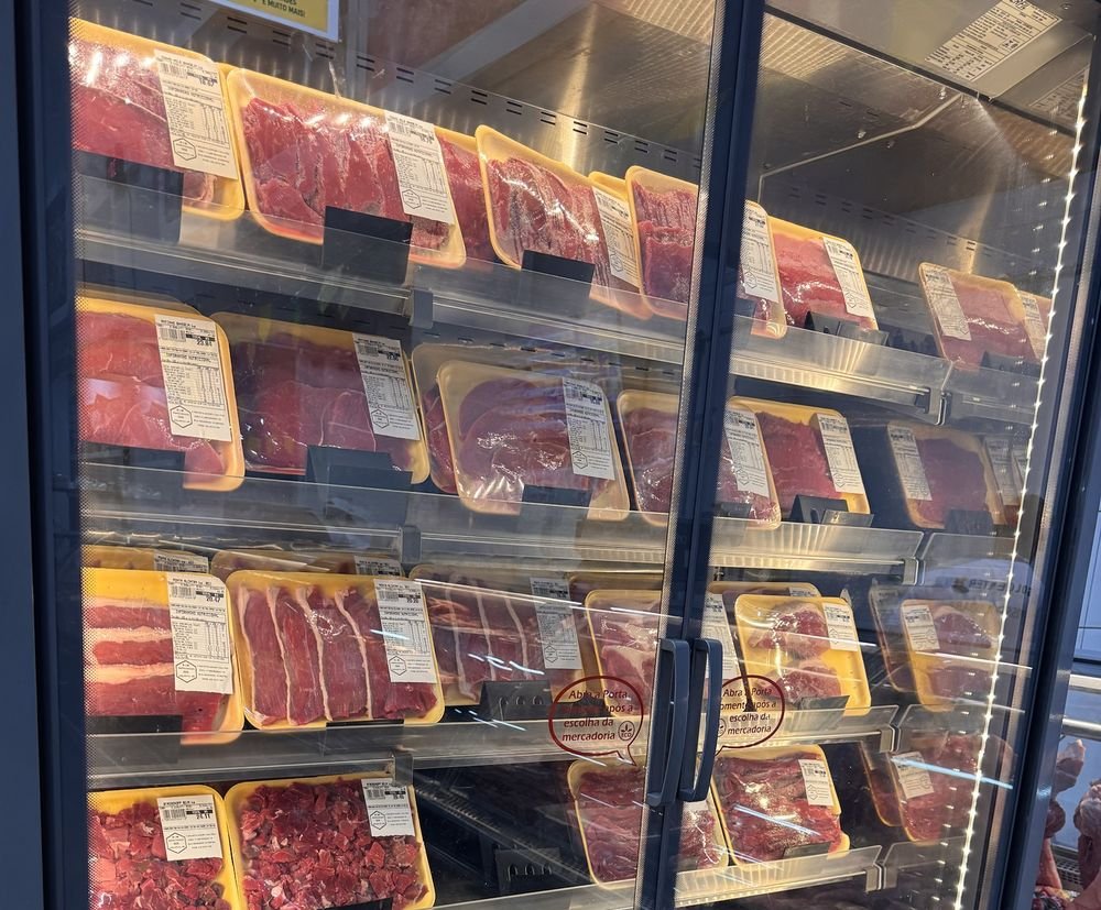 Expositor refrigerado com bandejas de carnes embaladas e etiquetadas